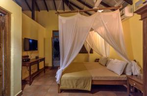 达博利SaffronStays Villa 270, Dapoli的一间卧室配有一张带蚊帐的床