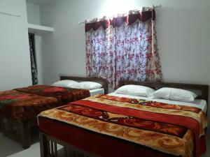 蒙纳Munnar Brindavan Cottage的一间卧室设有两张床和窗户。