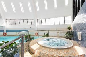 莫斯科莫斯科奥林匹克阿兹姆酒店的一座带游泳池的建筑中间的热水浴池