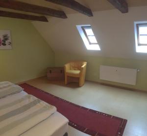 伊策霍Ferienwohnung Wilde - Holzkamp的阁楼间 - 带一张床和一把椅子