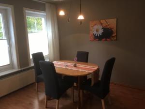 伊策霍Ferienwohnung Wilde - Holzkamp的一间带木桌和椅子的用餐室