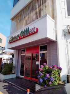西归浦市Slow Citi Guest House的前面有鲜花的慢洋葱商店