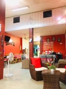 华欣Plaza Huahin的餐厅拥有红色的墙壁和藤椅