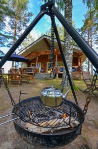 VehviläVacation Home Kuhmanne的烤架上的茶壶,设有小木屋