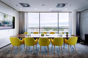 埃斯波GLO Hotel Sello的一间带桌子和黄色椅子的用餐室