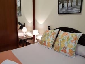 希洪PISO DE CALIDAD EN EL CENTRO DEL CENTRO DE GIJON的一间卧室配有一张带两个枕头和两个灯的床。