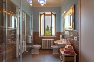 斯特拉达Agriturismo Villa Ulivello in Chianti的一间带水槽和卫生间的浴室以及窗户。