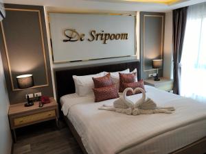 清迈Hotel De Sripoom -SHA Extra Plus的一间卧室配有一张大床,上面有标志