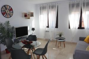 托莱多Apartamento Homelife Roca Tarpeya 4的客厅配有桌椅和电视。