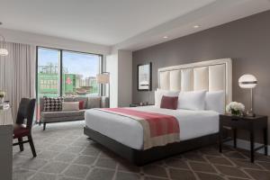 波士顿Hotel Commonwealth的一间带大床的卧室和一间客厅