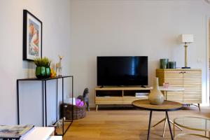 根特Modern Appartment in the Heart of Ghent的客厅配有平面电视和桌子。