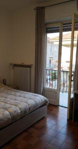 卡萨莱蒙费拉托Casa della Sala Spada的一间卧室设有一张床,并有通往阳台的门