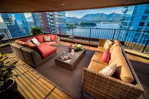 温哥华品纳寇海滨酒店的阳台配有沙发、椅子和桌子