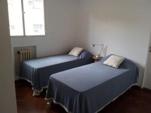 罗萨里奥Depto centrico, 90 m2, 2 habitaciones的配有两张床铺的蓝色床单和窗户