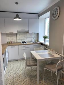 切尔尼戈夫Sisters apartment的厨房配有白色橱柜和桌椅
