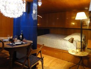 拉尼Bateau, Péniche Marboré - Disney的卧室配有1张床、1张桌子和1张桌子以及椅子。