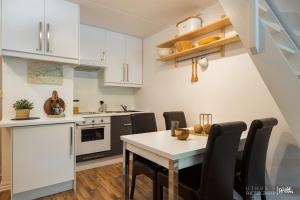 奥尔Actif 305 Apartment by Ål Ski Center的厨房配有白色橱柜和桌椅