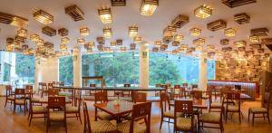 马丘比丘Tierra Viva Machu Picchu Hotel的餐厅设有桌椅和大窗户。
