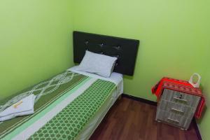 利马Hospedaje el viajero-Aeropuerto的绿色卧室,配有一张带黑色床头板的床