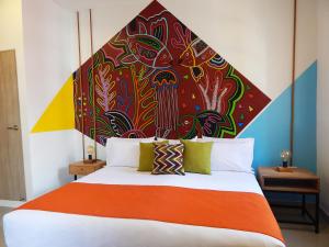 卡塔赫纳ETHNIC Thematic Hotel的一间卧室配有一张大床和色彩缤纷的床头板