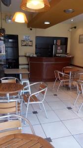 皮乌拉Hostal Resident的一间设有桌椅的餐厅,并提供现金登记册