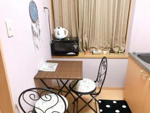 神户Mori de house in Kobe 201的小厨房配有桌椅和微波炉。