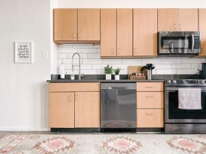 诺克斯维尔Modern Loft w/ View的厨房配有木制橱柜和不锈钢洗碗机。