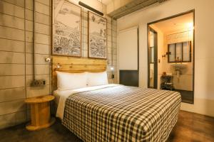 台北Hotel PaPa Whale的一间卧室配有一张带 ⁇ 子毯子的床