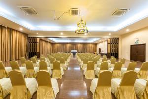 芭堤雅市中心Hotel Tropicana Pattaya的一间会议室,里面摆放着一排椅子和讲台
