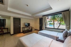 芭堤雅市中心Hotel Tropicana Pattaya的酒店客房设有两张床和大窗户。