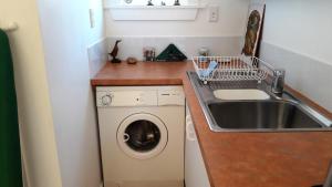 杰拉尔丁Rivendell的小厨房配有洗衣机和水槽