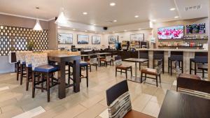 堪萨斯城KCI东堪萨斯城机场贝斯特韦斯特酒店的一间带桌椅的餐厅和一间酒吧