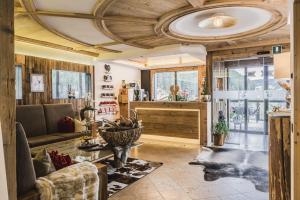 塞尔瓦迪加尔代纳山谷Hotel Chalet S - Dolomites Design - adults recommended的客厅配有沙发和桌子