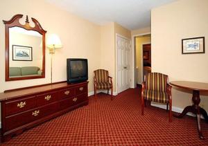 费耶特维尔大使汽车旅馆的酒店客房配有电视、桌子和椅子。