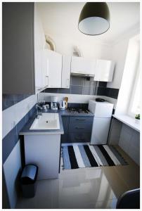 斯塔洛瓦沃拉Color 24 Apartament II的白色的厨房设有水槽和炉灶。