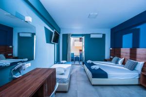 斯塔里斯斯塔里斯酒店的蓝色的客房配有两张床和一张桌子