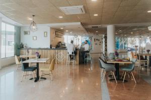 穆尔西亚Allegro Murcia Azarbe的餐厅设有桌椅,厨房内有工作人员