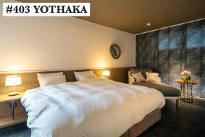京都La Viola的酒店客房设有一张白色大床和椅子