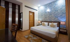 古尔冈富通帝国公寓的一间卧室设有一张床和蓝白色的墙壁