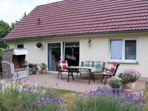 赫亨基尔兴Cozy Holiday Home in Hohenkirchen near Baltic Sea的房屋前设有带桌椅的天井。