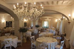蒙泰韦尔迪马里蒂莫Relais I Piastroni的一间设有白色桌子和吊灯的用餐室