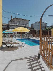 Aldea del FresnoApartamentos "Casa Rural de Aldea"的游泳池旁的黄色遮阳伞和椅子