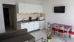 蒂亚斯Apartamento Puerto del Carmen Las Vistas 247的厨房配有白色橱柜和带微波炉的桌子。