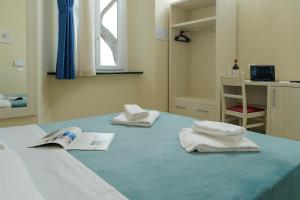 波普洛尼亚Hotel Il Mulinaccio的一间设有床铺和毛巾的房间