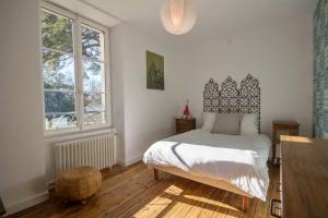米济亚克Villa des Mimosas的一间卧室设有一张床和一个大窗户