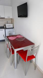 蒂亚斯Apartamento Puerto del Carmen Las Vistas 247的厨房里摆放着红色的桌子和椅子