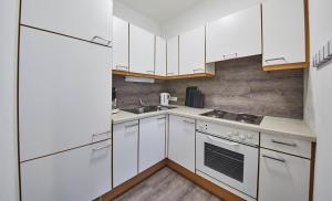 萨尔巴赫Appartements Living Saalbach的白色的厨房配有白色橱柜和水槽