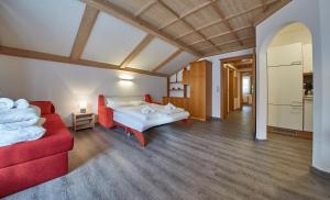 萨尔巴赫Appartements Living Saalbach的客厅配有两张床和一张红色沙发
