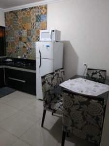 马林加Residência Cidade Verde 4的厨房配有白色冰箱、桌子和椅子