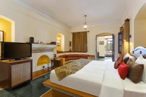 哈里瓦The Haveli Hari Ganga by Leisure Hotels的一间卧室设有一张大床和一个壁炉